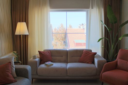 Inviting living room with plush sofa, warm lighting, and a view of Ankara rooftops.