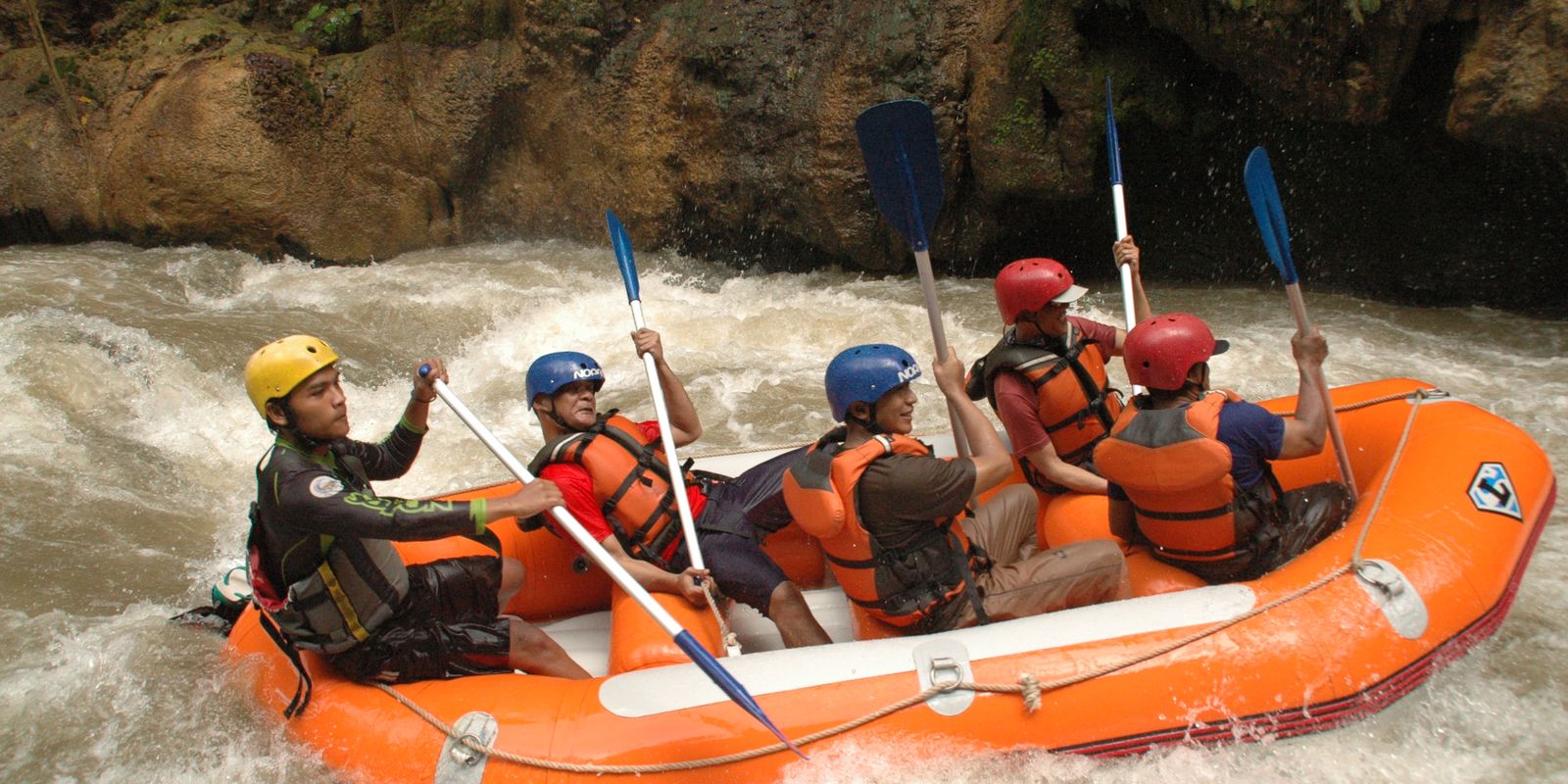 A group whitewater rafting through a canyon