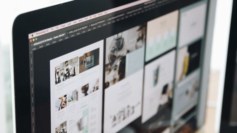 A modern computer screen displaying web design work, showcasing creative visuals in a workspace.