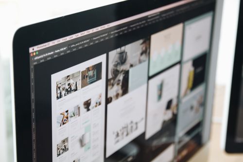 Monitor displaying illustration and layout work in design software