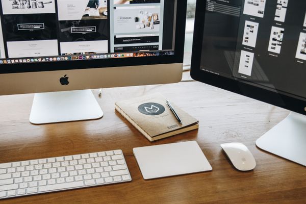 Clean website design workspace with keyboard and dual monitors
