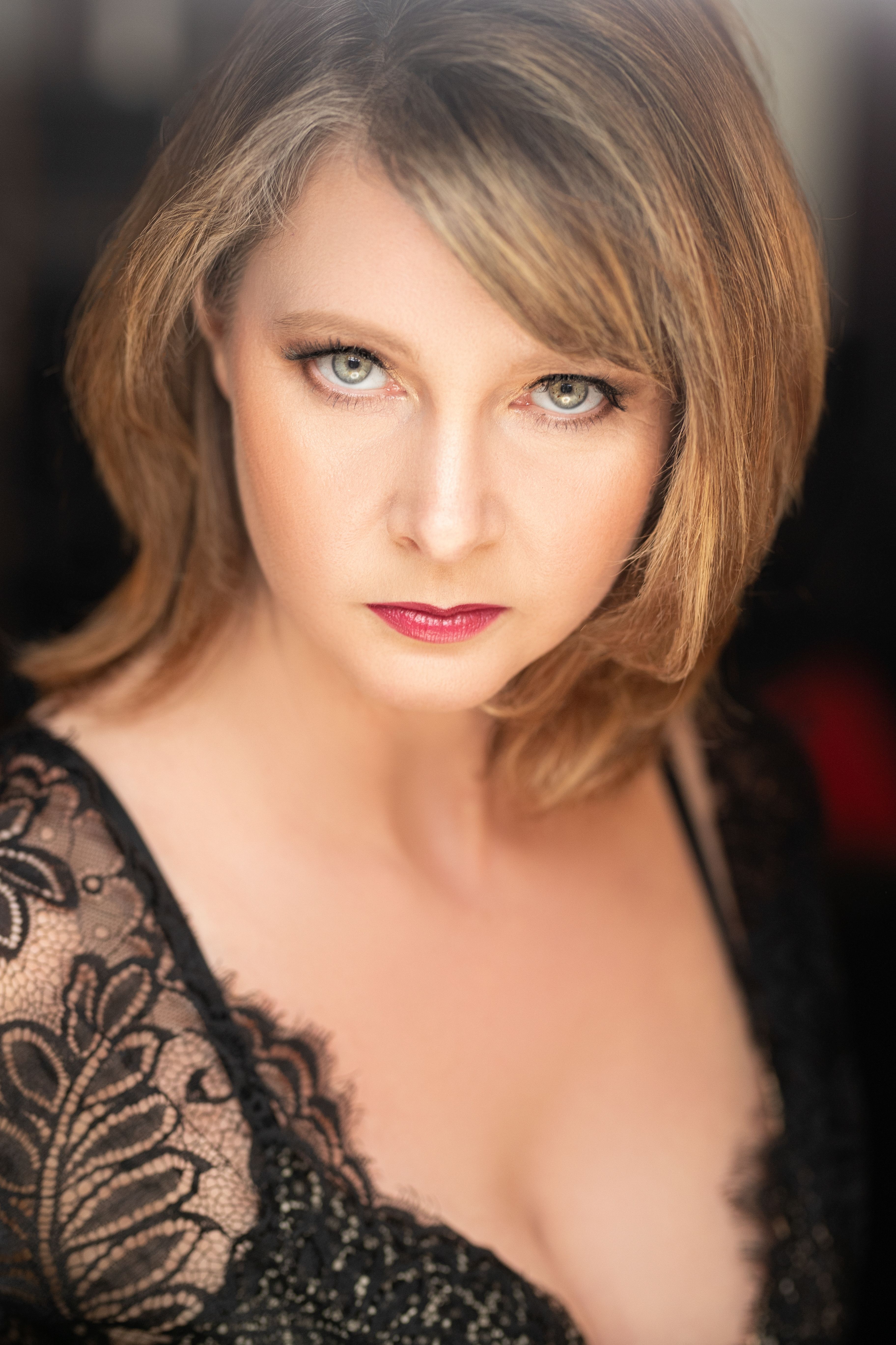 Close-up portrait of a sophisticated woman in lace attire, exuding elegance.