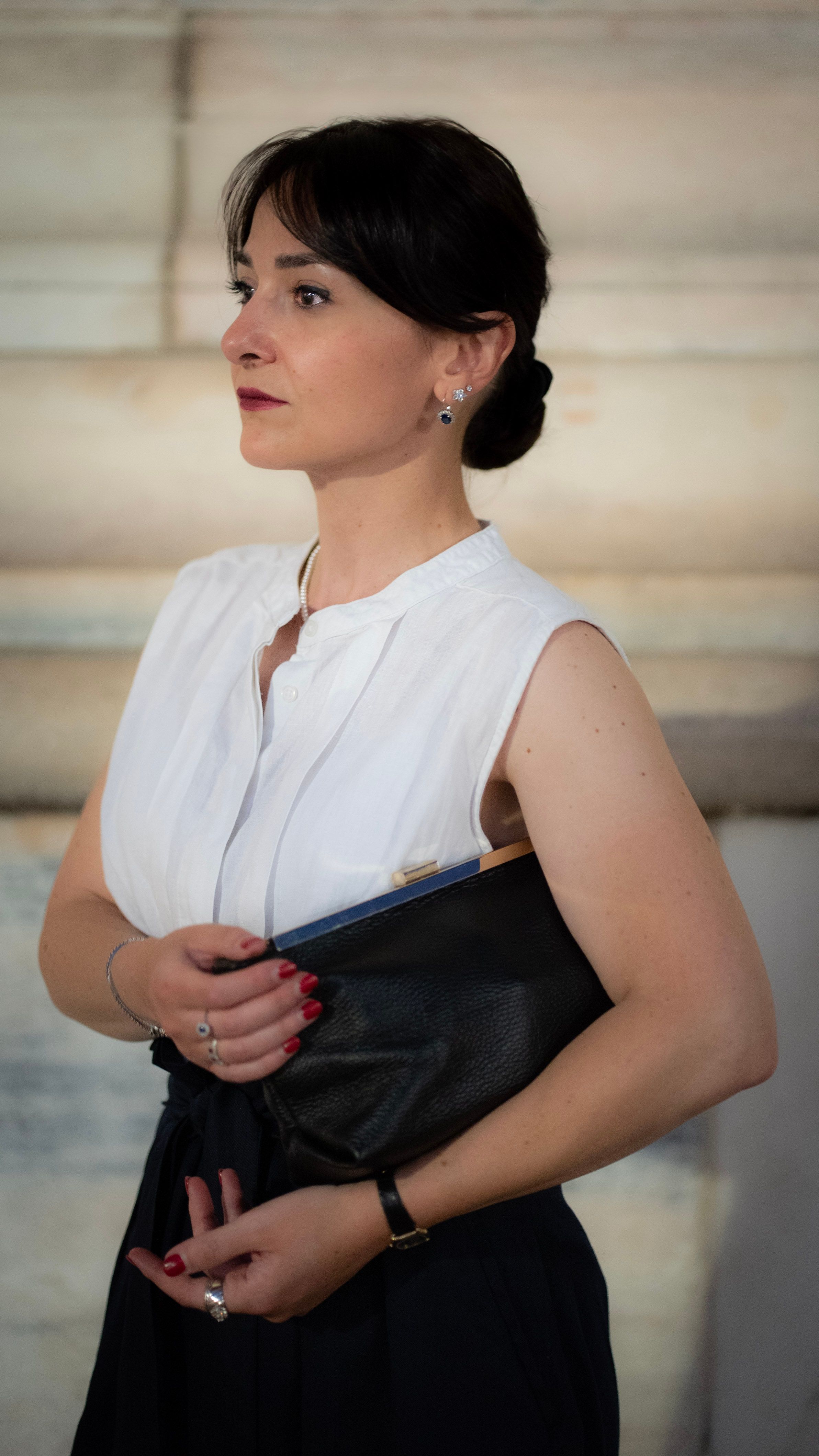 Sophisticated woman poses with handbag, exuding elegance in Milan, Italy.