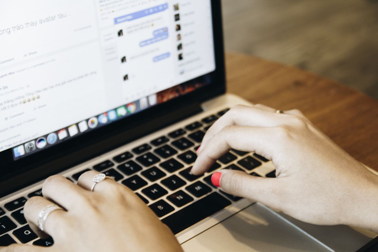Hands typing on a laptop keyboard