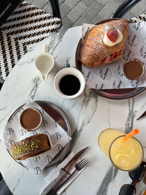 Free Marble table with pastries, coffee, and orange juice in a chic outdoor setting. Stock Photo
