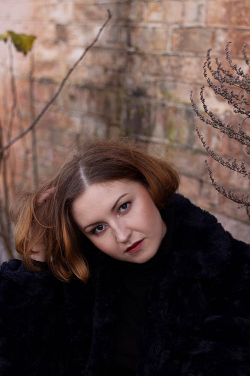 Woman Sitting Near Brown Wall