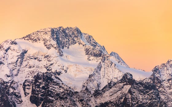 Stunning snow-capped mountains in Lanzada, Italy during a vibrant sunrise.
