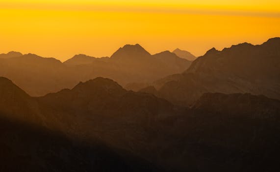 Breathtaking sunset view of mountains in Aosta Valley, Italy, with warm golden hues.