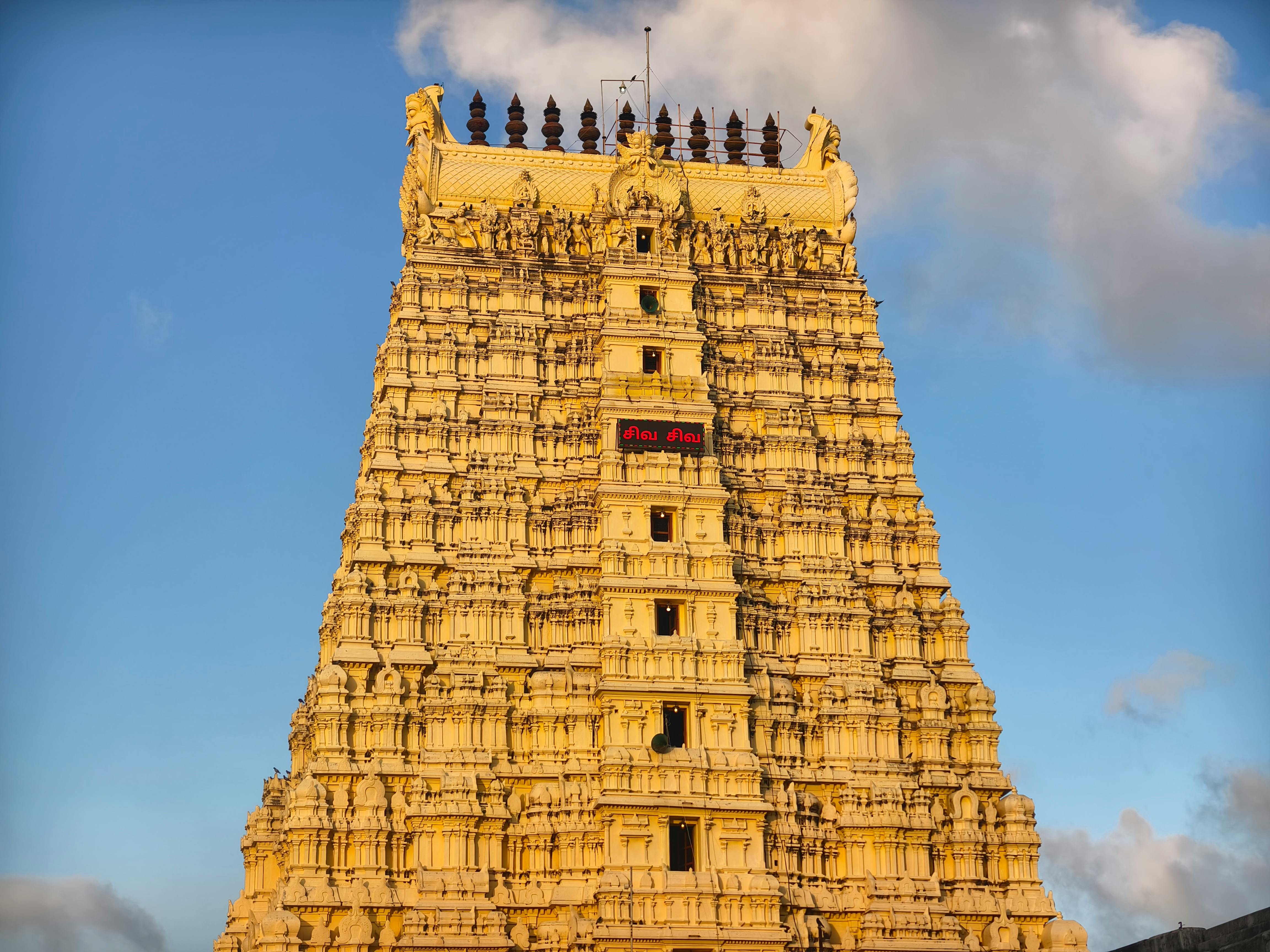 Magnificent view of Rameswaram temple gopuram with intricate carvings under clear blue sky.