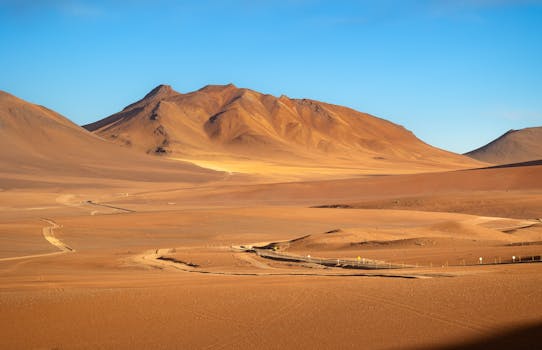 A breathtaking sunset view of the Atacama Desert in Chile, showcasing dramatic dunes and mountains.