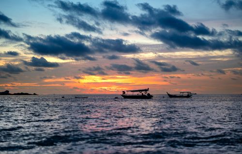 Free Peaceful boats float during a vibrant sunset over Pangkor Island, Malaysia. Stock Photo