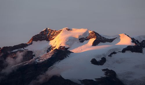 Free Captivating view of snow-covered mountain peaks glowing during sunset in Aosta Valley, Italy. Stock Photo