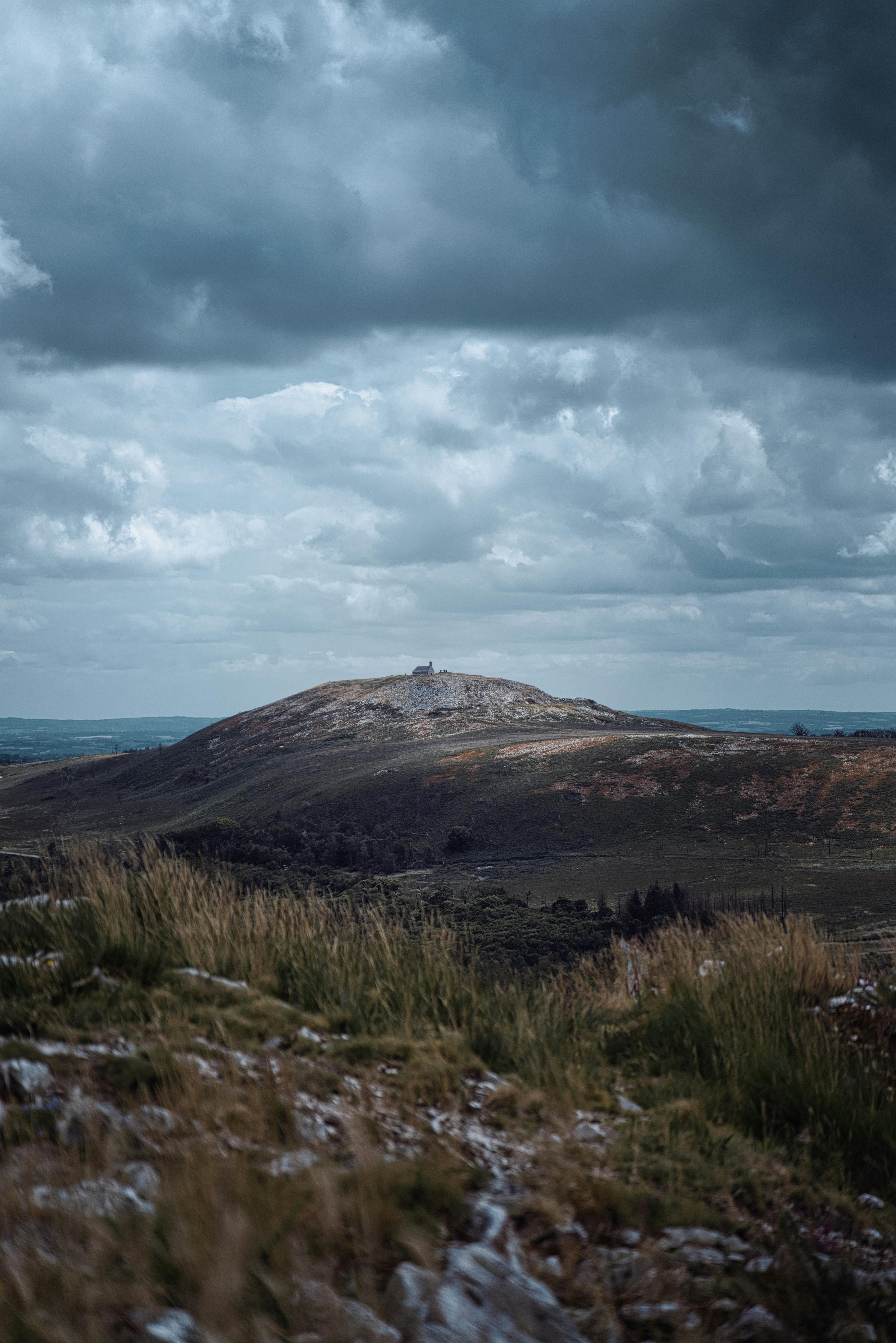 A moody landscape in Bretagne, France, with a hill under a dramatic sky.