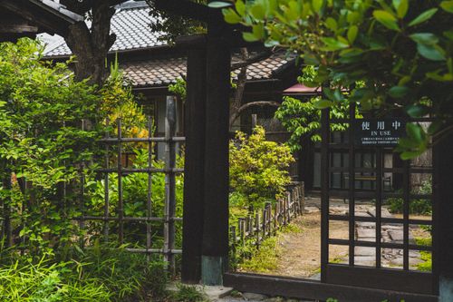 Free A serene Japanese garden featuring traditional wooden architecture and lush greenery, offering a peaceful escape. Stock Photo
