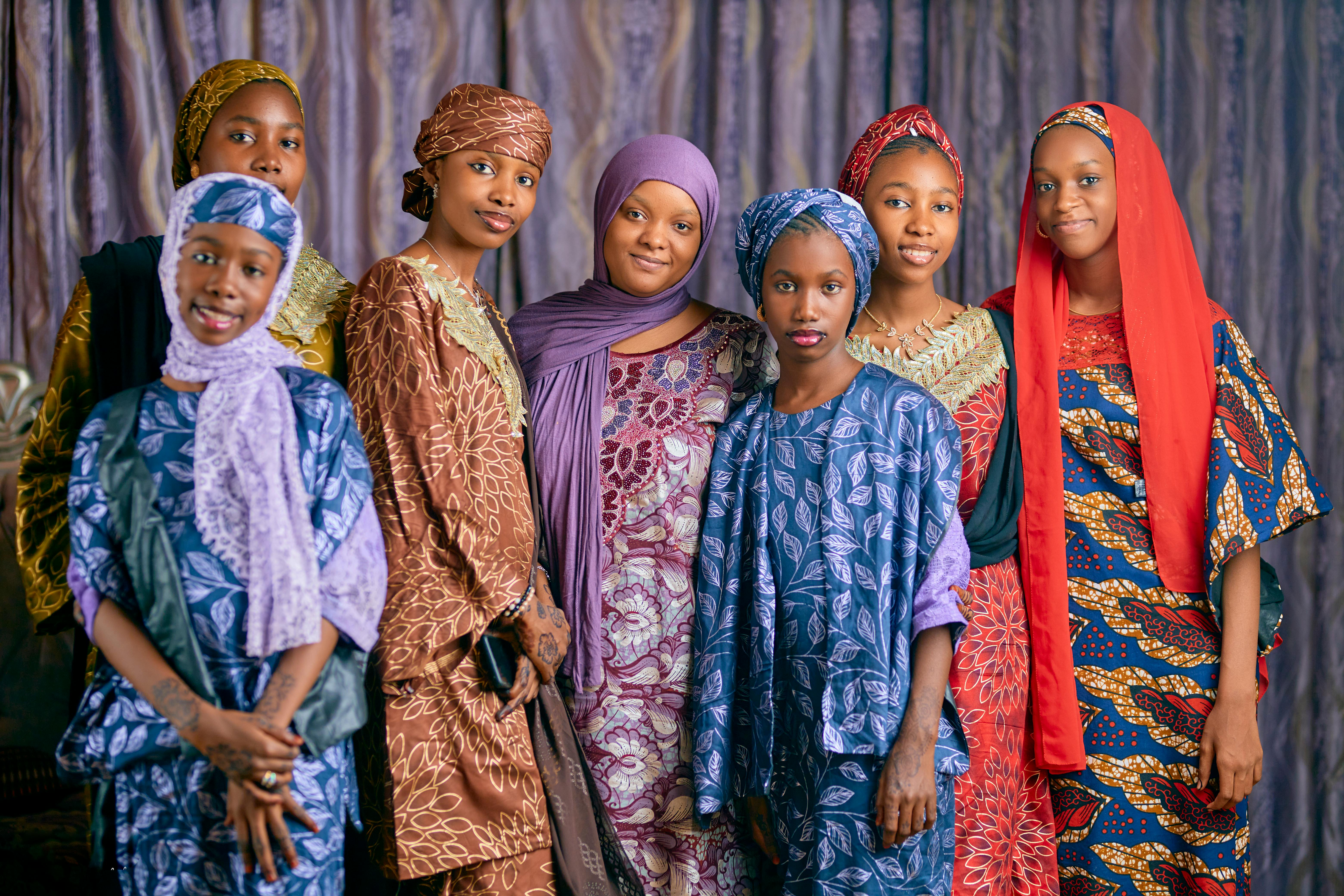 Gratuit Un portrait de groupe dynamique de femmes portant des vêtements traditionnels africains colorés à l'intérieur. Photos