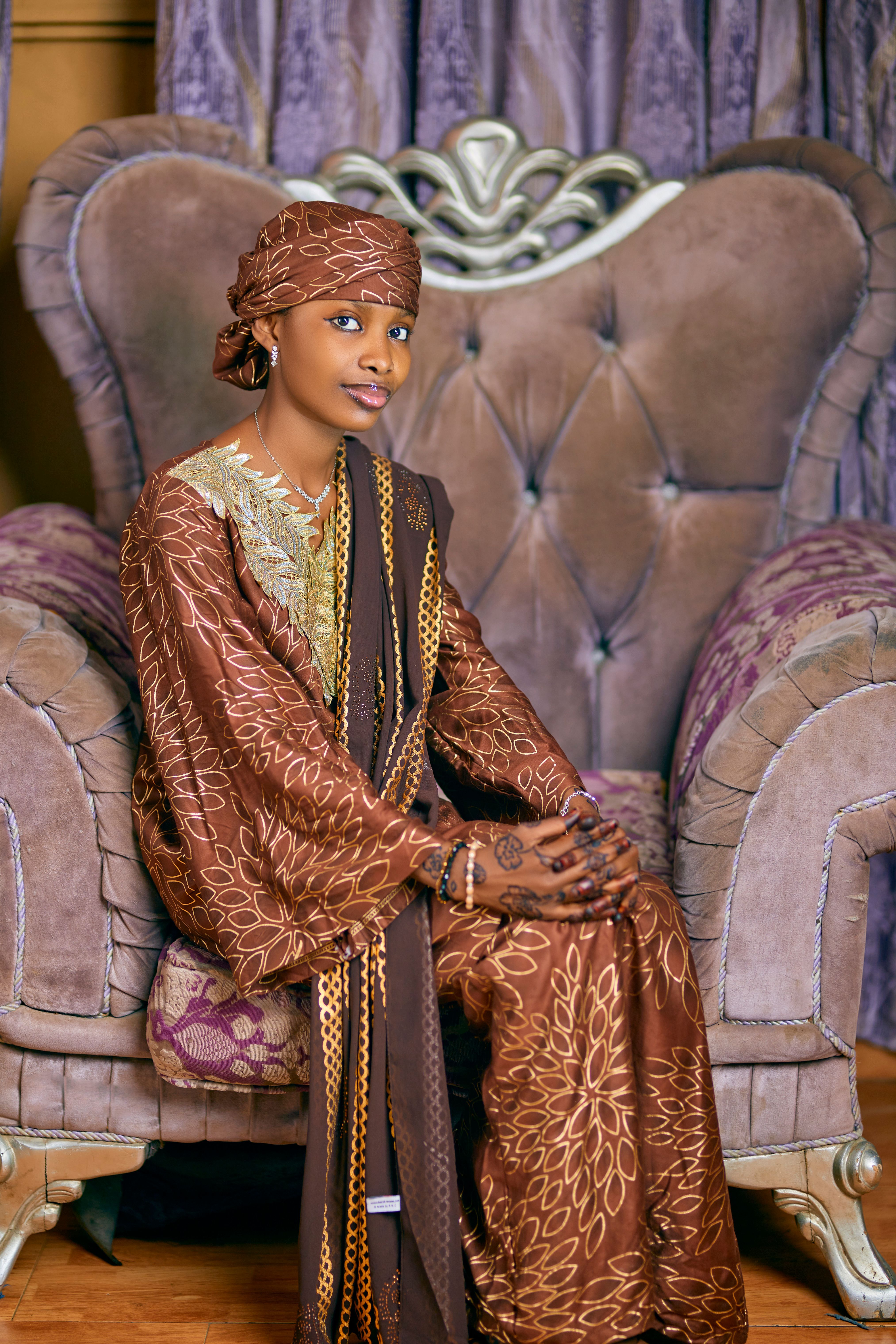 Elegant Woman in Traditional Brown Attire Sitting Indoors · Free Stock ...