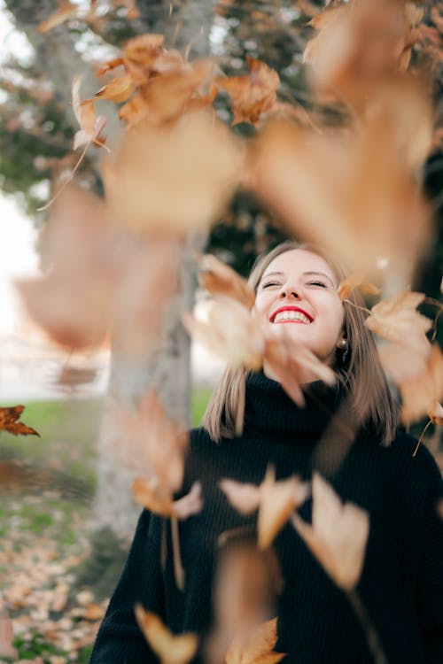 Photo Of Woman Standing Under Falling Leaves
