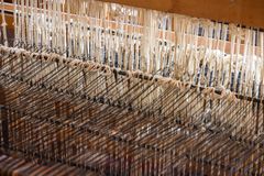 Detailed view of a weaving loom with alpaca wool threads in an artisanal setting.