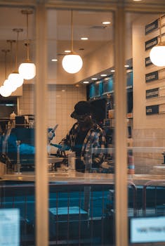 Warm, inviting view of a barista in a stylish coffee shop creating beverages.