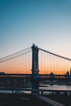 A stunning view of Manhattan Bridge against a colorful sunset in New York City.
