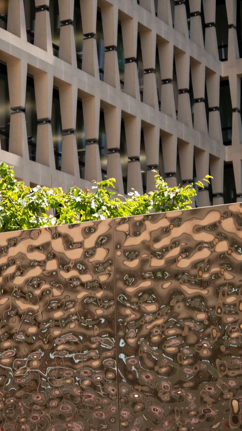 Free Abstract urban landscape featuring textured metal, modern architecture, and lush greenery. Stock Photo
