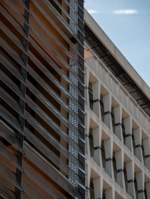 Free Close-up of modern building facade with geometric patterns against a clear blue sky. Stock Photo