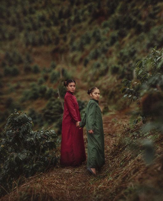 Two sisters in colorful dresses explore lush hills of Tingo María, Perú.