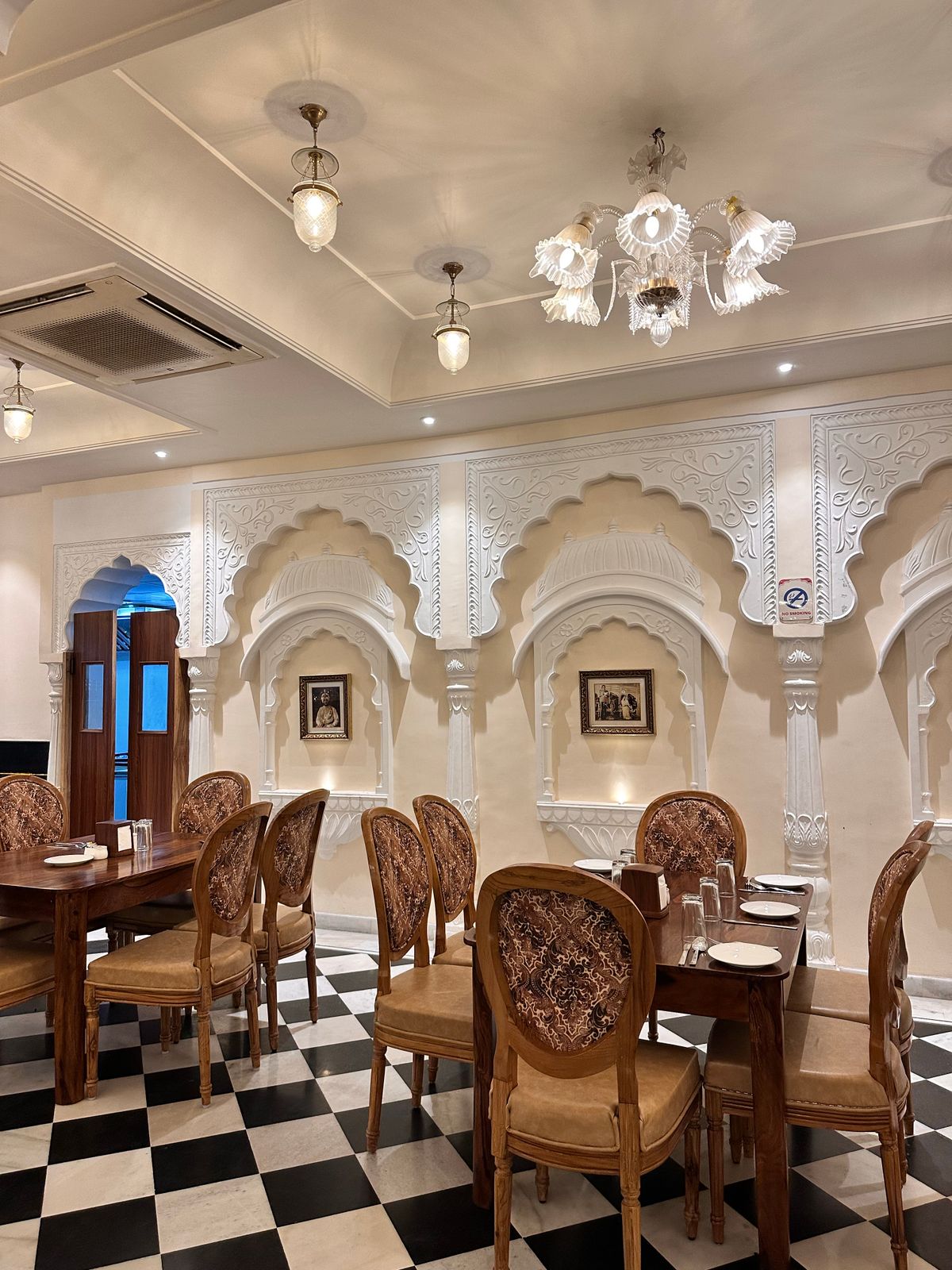 The dining room, with arched alcoves and warm lamps