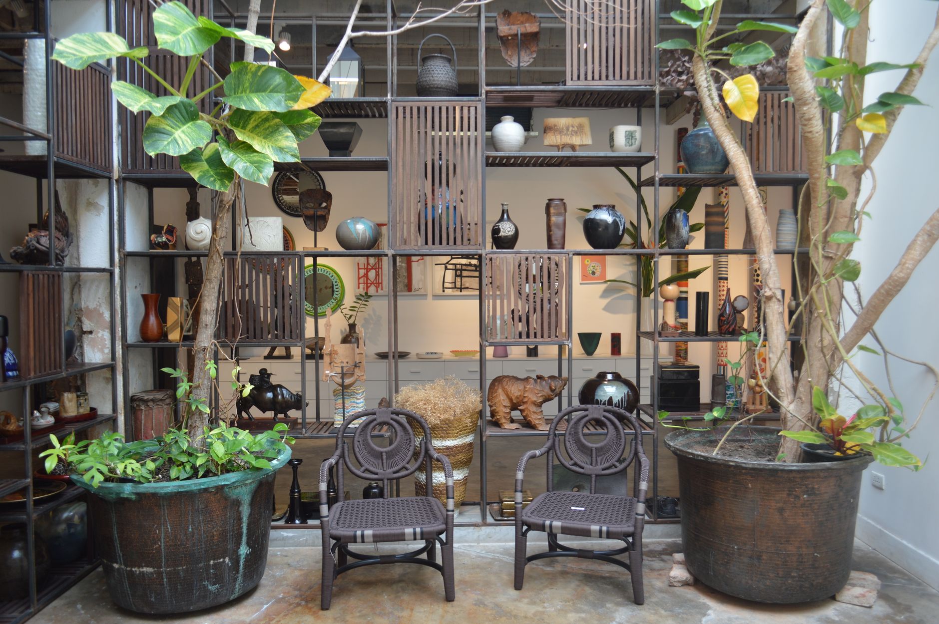 modern patio design for modern homes Rustic indoor patio with decorative shelving, pottery, and lush potted plants for a cozy atmosphere.