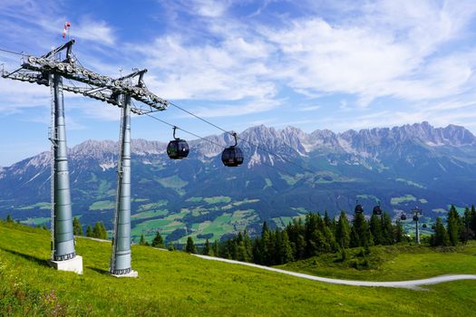 A stunning view of cable cars ascending through the Wilder Kaiser mountains in Tirol, Austria.