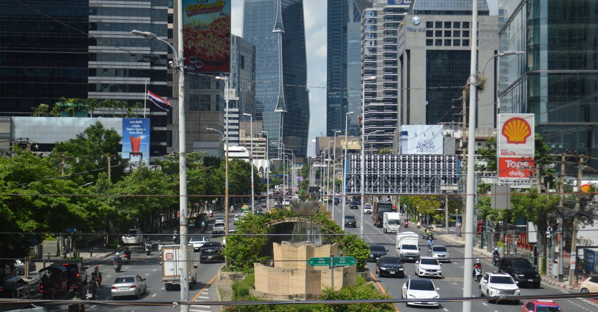 A vibrant view of Bangkok's bustling business district with modern skyscrapers and heavy traffic.