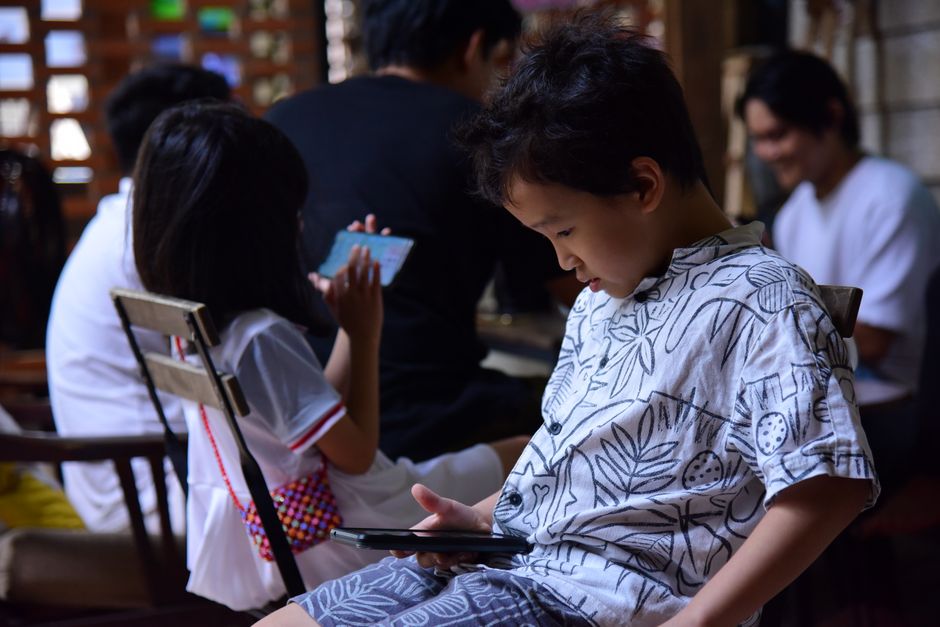 スマホやタブレットを使う家族の子どもたち