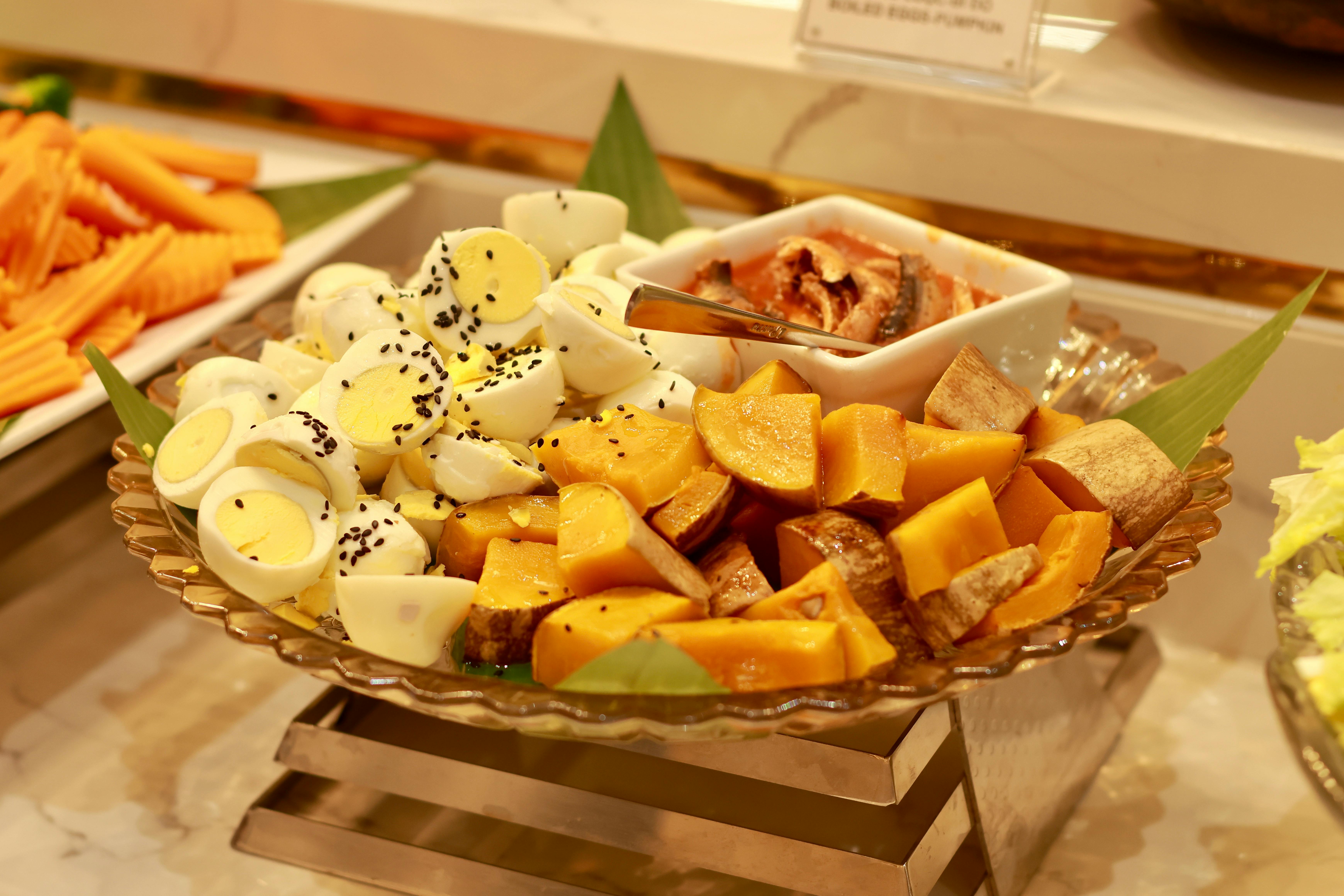 Delicious buffet platter featuring sliced eggs, sweet potatoes, and vegetables.