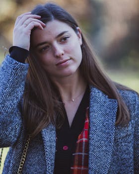 一位时尚女性身着人字形西装外套，在户外拍摄肖像，展现纽约市的秋季风尚