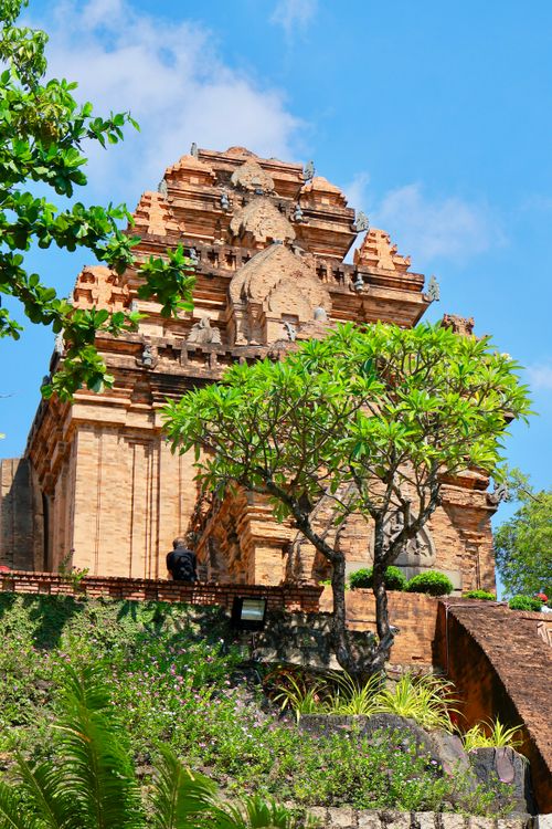 Free Explore the historic Cham temple surrounded by vibrant greenery and blue skies. Stock Photo