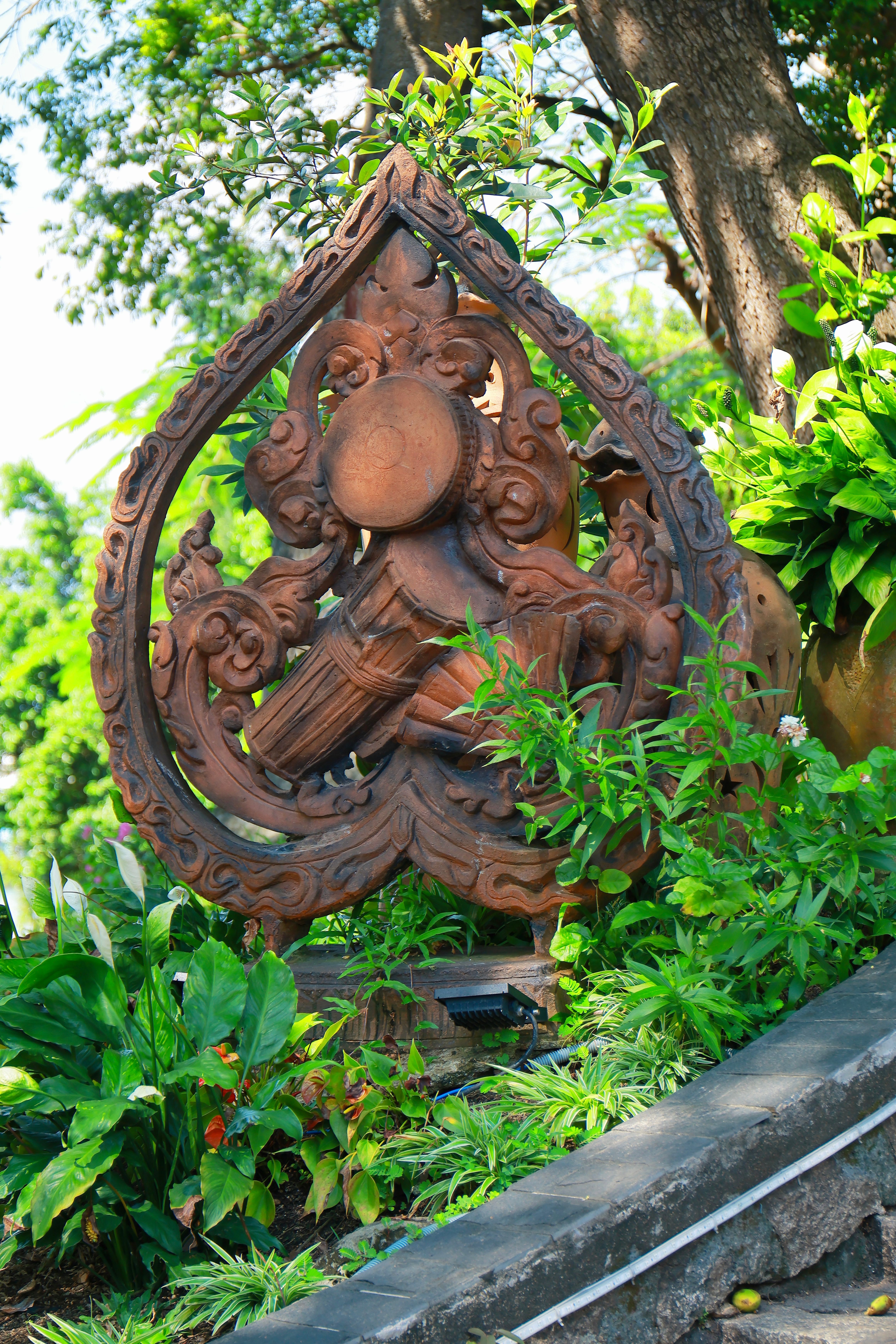 Intricate Wooden Sculpture in Lush Garden Setting