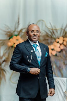 Confident businessman in a formal suit at an elegant event setting, exuding professionalism and style.