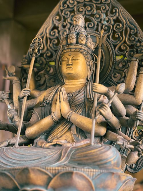 Free A detailed bronze Buddhist statue with multiple arms, symbolizing spirituality. Stock Photo