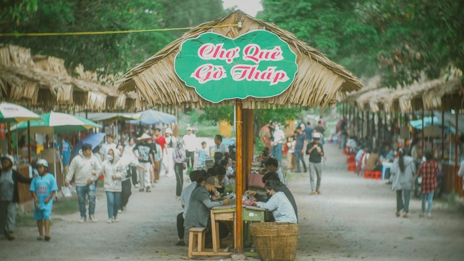 Seasonal food scene in Dong Trieu, steaming hot dishes on a cool day, diners enjoying warm soup and traditional foods, atmospheric Vietnamese town setting, cinematic realism