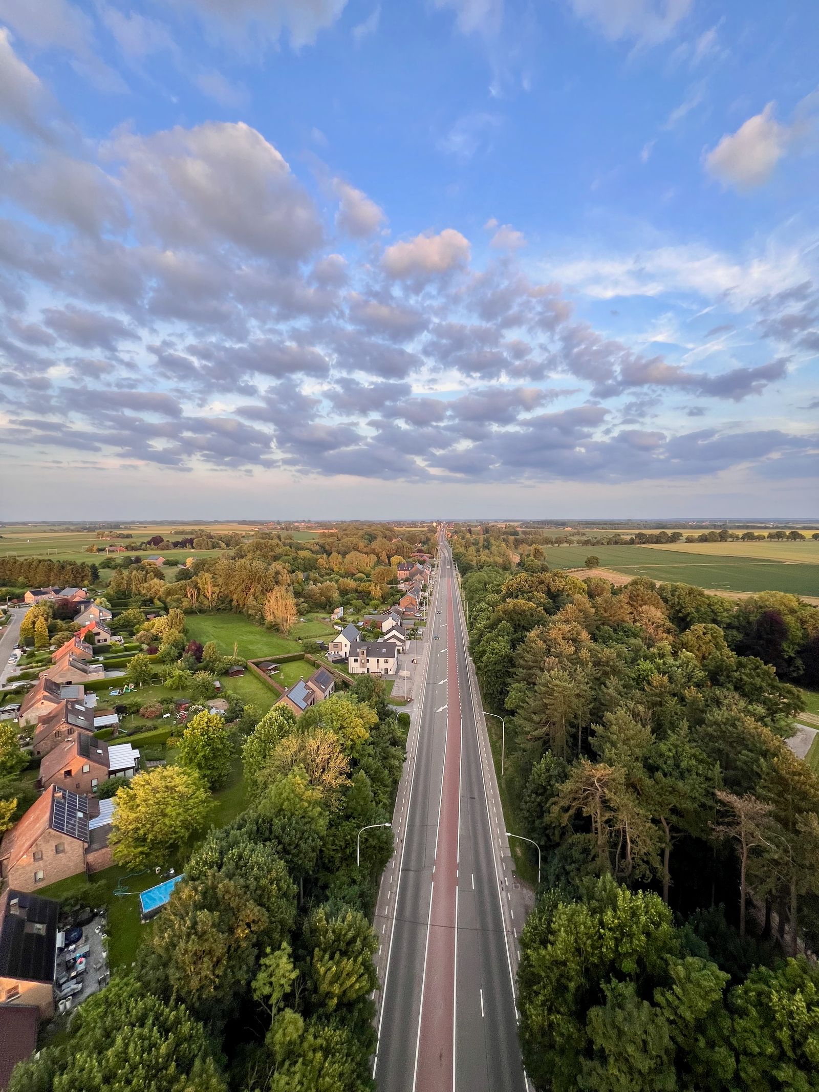 Aerial drone view of a rural countryside road running through farmland