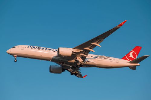 Free Turkish Airlines Airbus A350 soaring through clear blue skies. Stock Photo