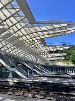 Contemporary train station featuring sleek glass structures and unique design under clear blue skies.