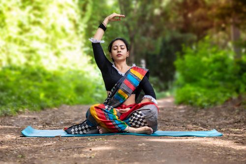 Free Woman practicing yoga outdoors in Bengaluru, embracing traditional poses and inner peace in lush surroundings. Stock Photo