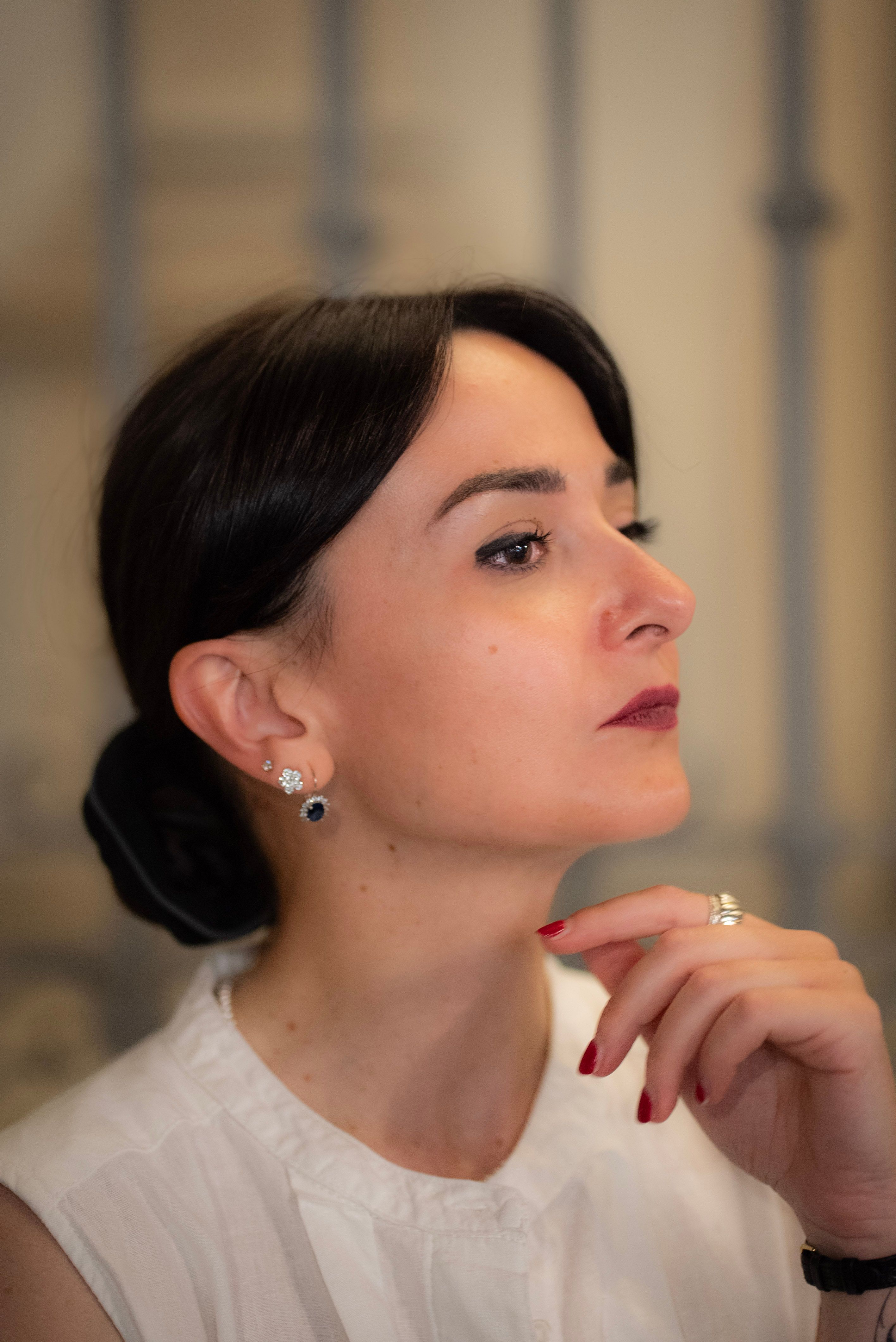 Profile of a young woman posing gracefully indoors in Milan, showcasing elegance and style.