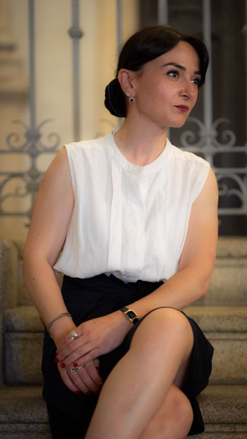 Free Stylish woman sitting elegantly on stairs in Milan, showcasing fashion and grace. Stock Photo