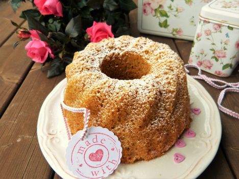 Sweet homemade Bundt cake dusted with sugar, set with roses for a heartfelt occasion.
