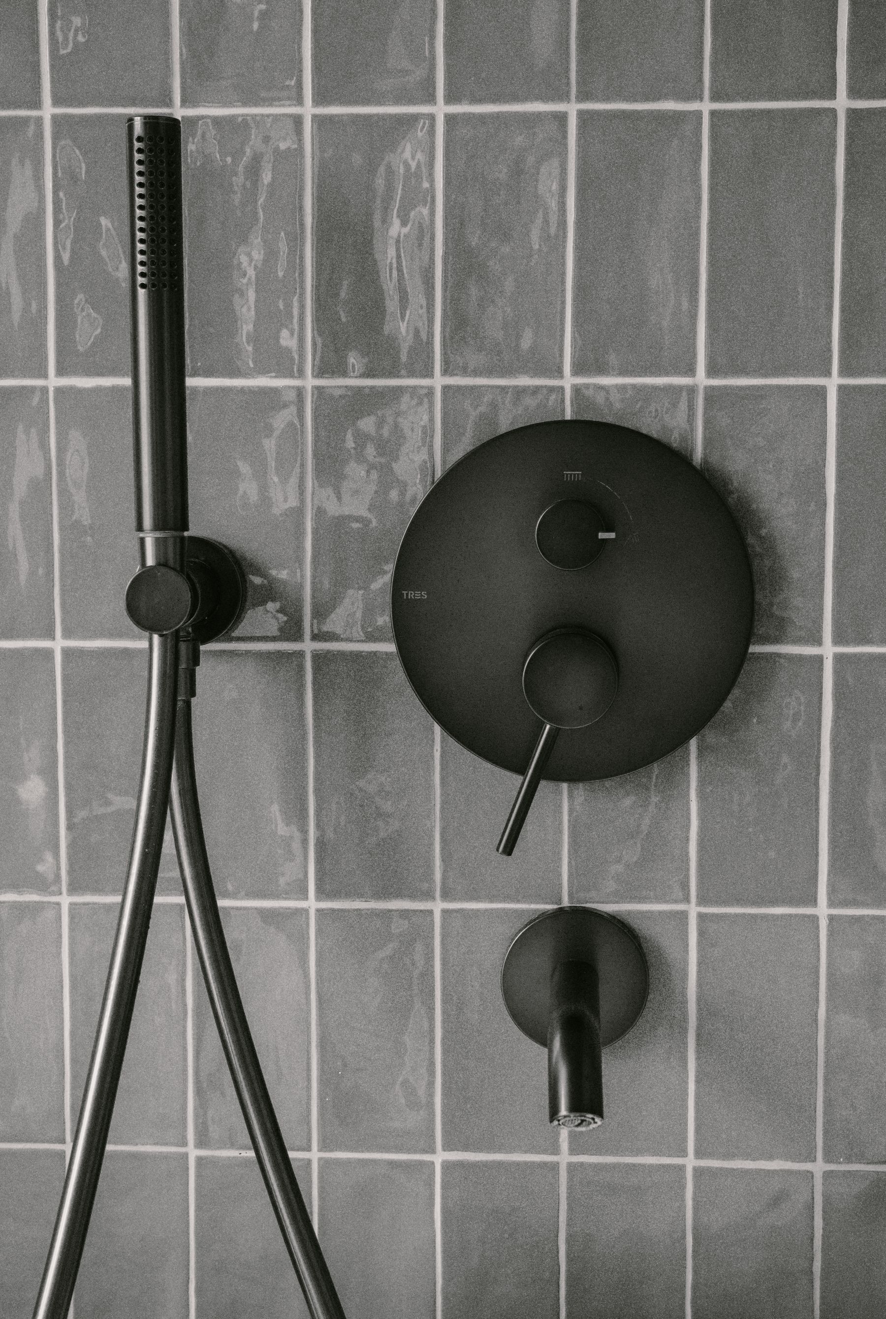 Matte black shower fixtures on a modern tiled wall