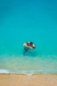 A child in a float enjoys the pristine turquoise waters off the coast of Antalya, Türkiye.