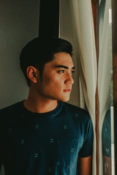 一个年轻人若有所思地凝视着窗外的肖像