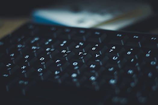 Moody close-up of black keyboard keys with blue lighting effect. Ideal for tech themes.